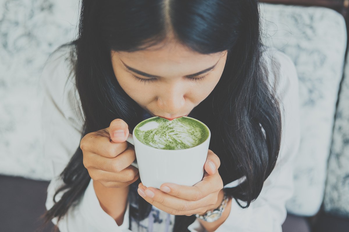 Matcha Tee Genuss Frau trinkt Matcha Tee aus weißer Tasse